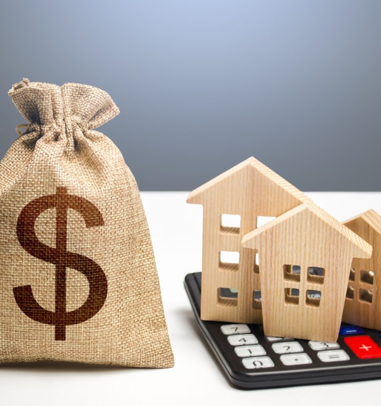 Houses on a calculator and dollar money bag.